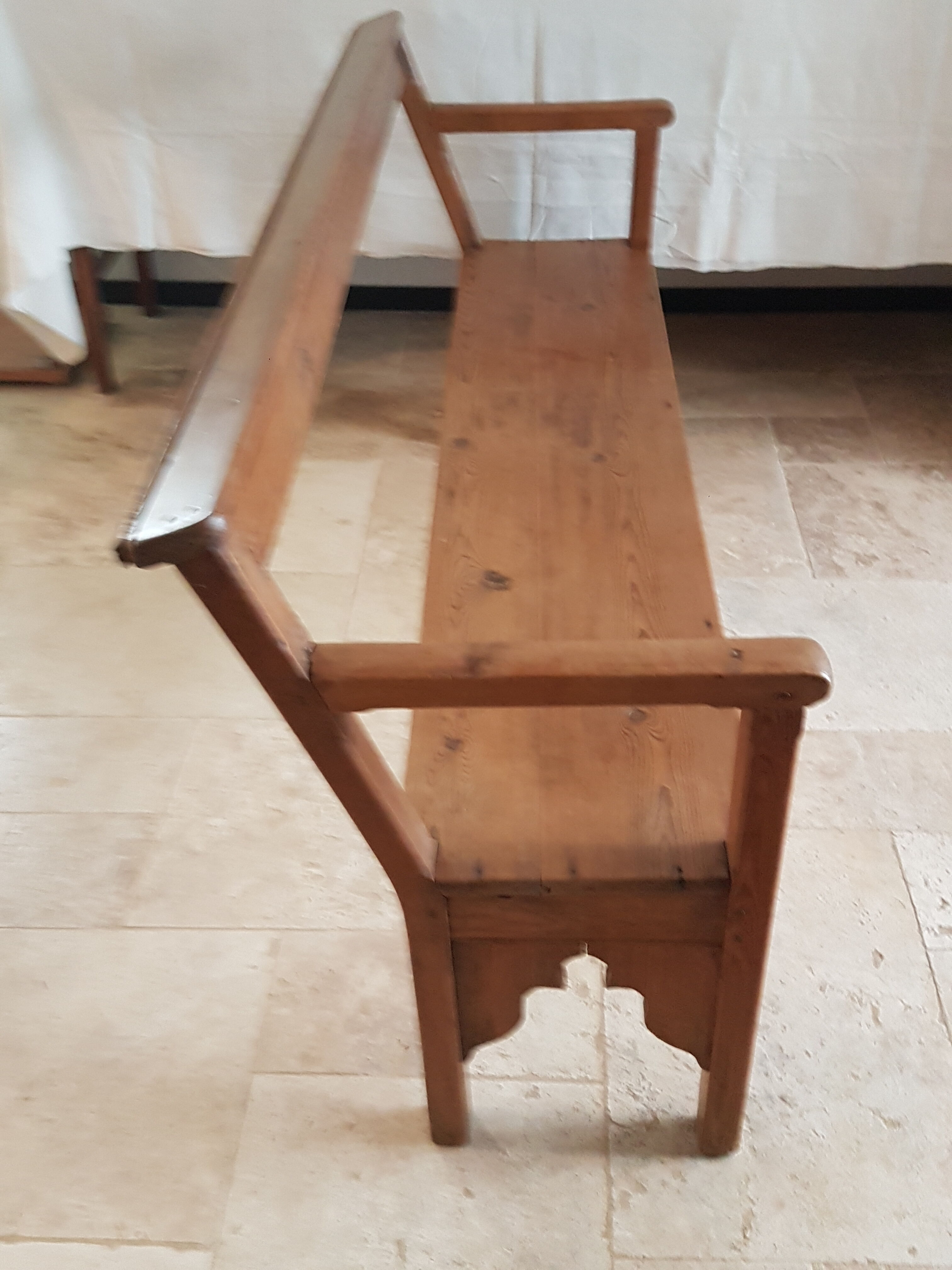 Church bench in fir tree with armrests