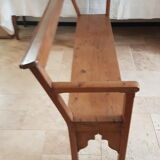Church bench in fir tree with armrests