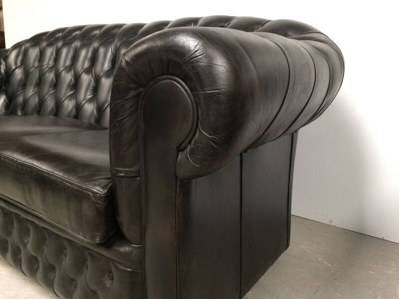 Three-seater black leather chesterfield sofa