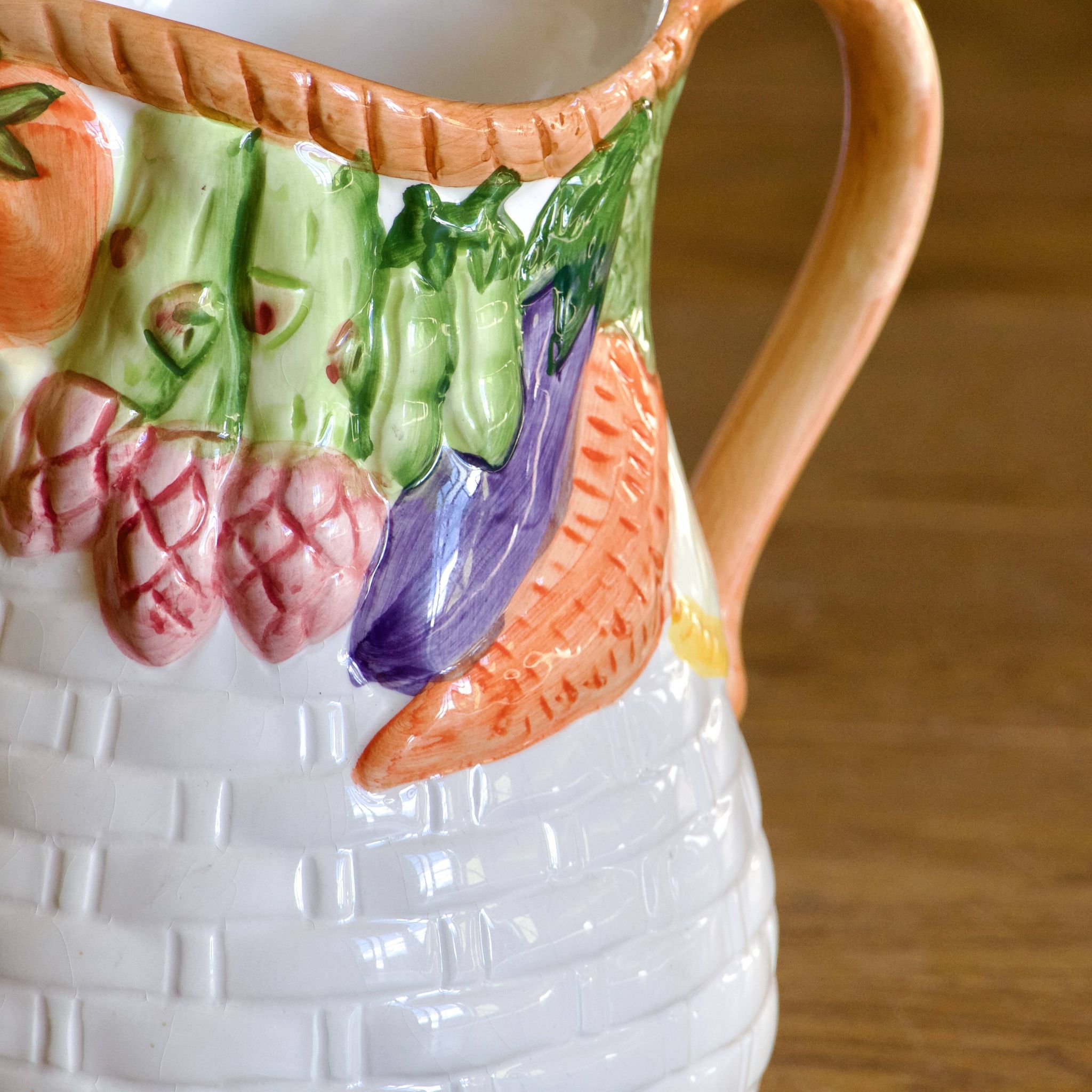 Hand-painted earthenware carafe with a raised vegetable basket design