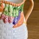 Hand-painted earthenware carafe with a raised vegetable basket design