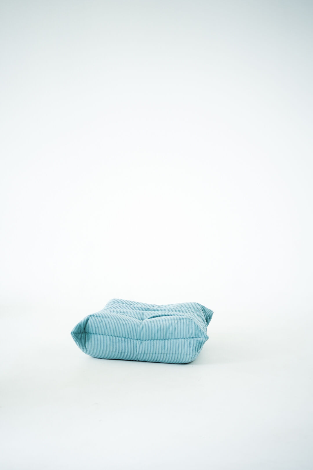 Ensemble de fauteuil et pouf Togo en velours côtelé bleu clair.