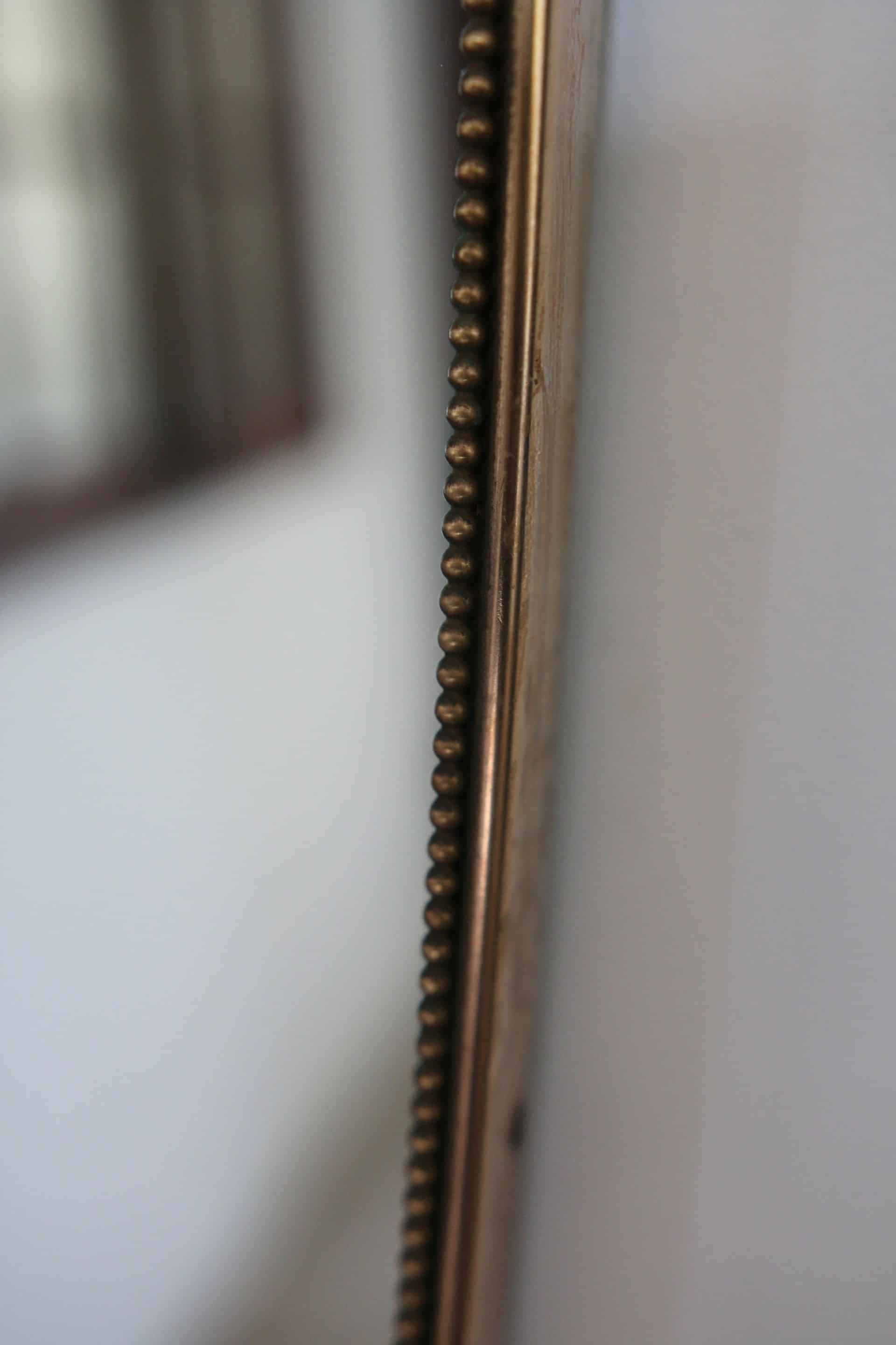 Brass mirror with crest, bead frieze, Italian design style.