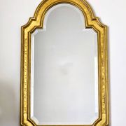 Florentine arched mirror in gilded wood with gold leaf.