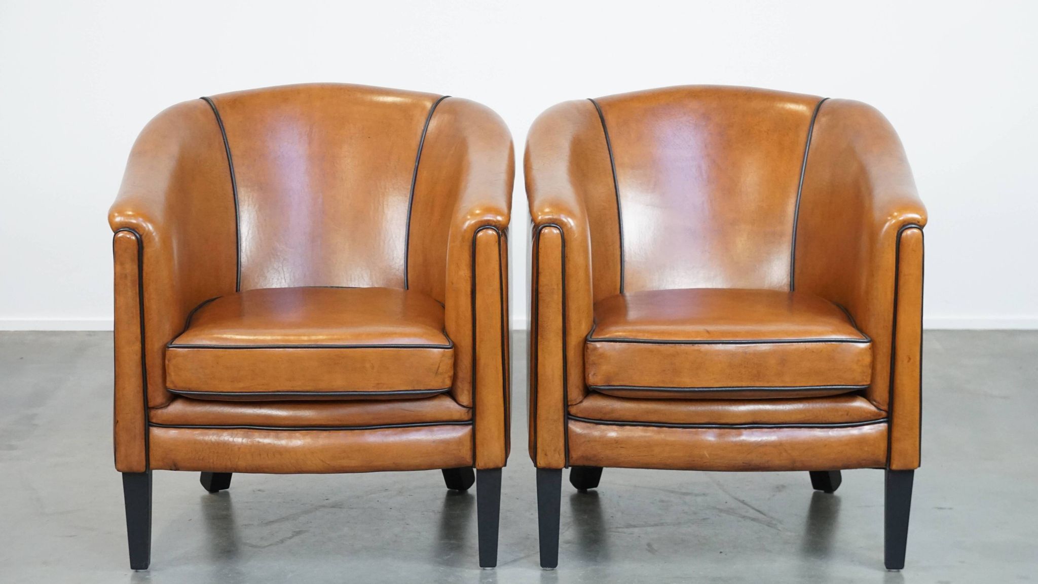 Set of 2 sheep leather club chairs finished with black piping