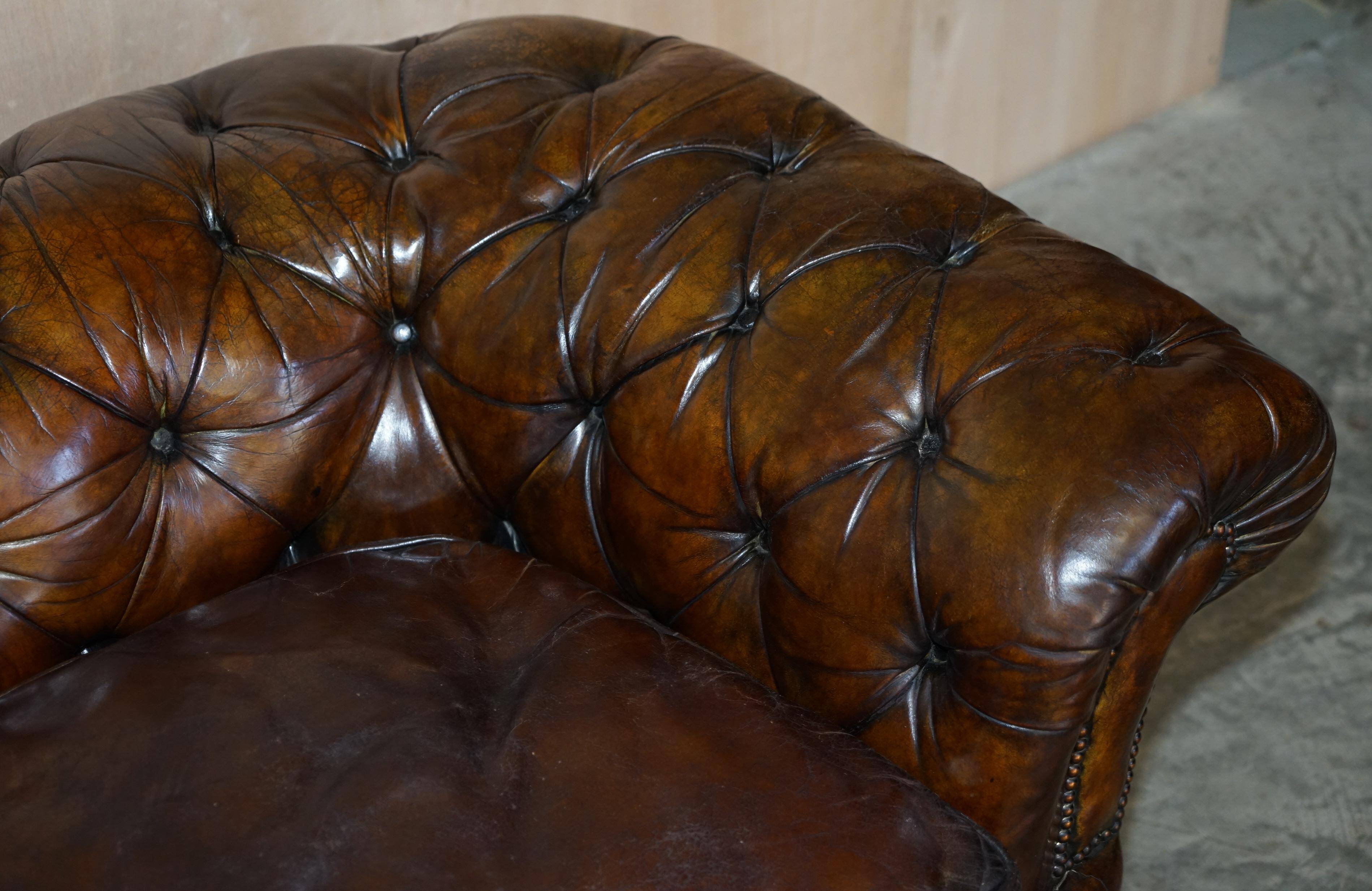 Victorian Chesterfield leather upholstered canapé with feather cushions.