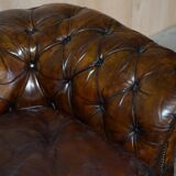 Victorian Chesterfield leather upholstered canapé with feather cushions.