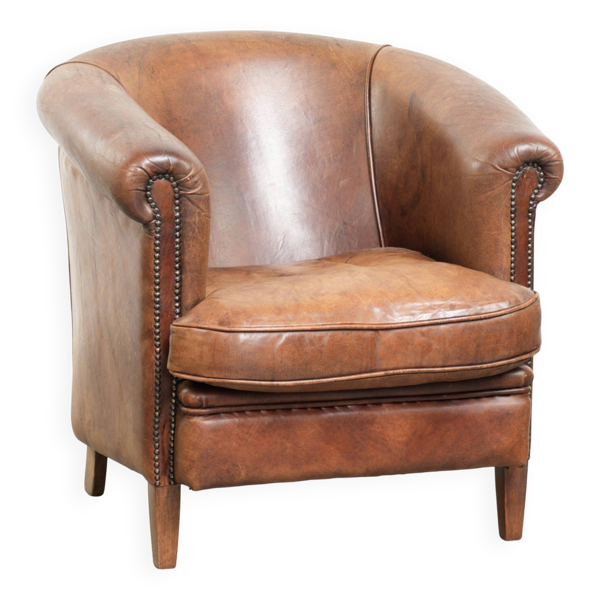 Fauteuil club en peau de mouton couleur cognac avec un look vintage de style anglais.
