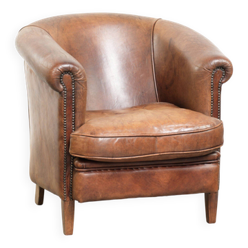 Fauteuil club en peau de mouton couleur cognac avec un look vintage de style anglais.