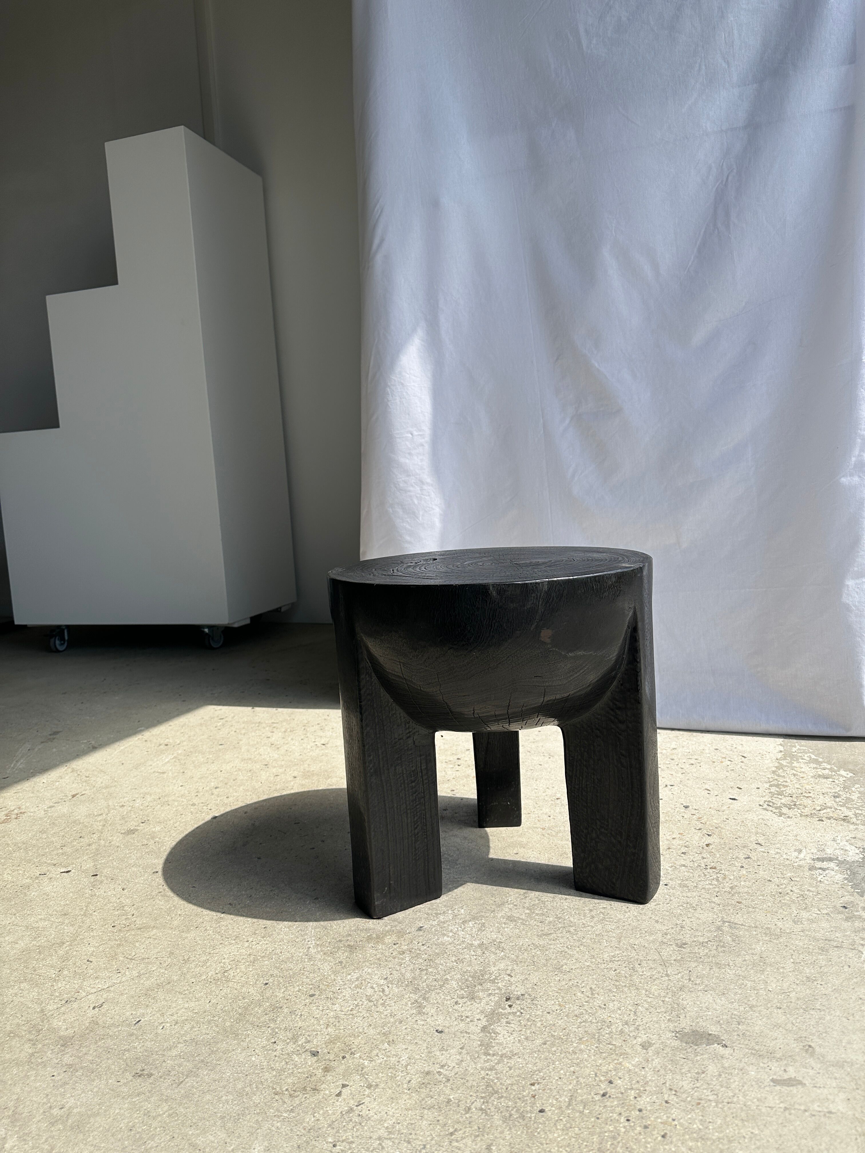 Black mango wood tripod side table with a semi-spherical top, height: 45 cm, diameter: 44 cm.