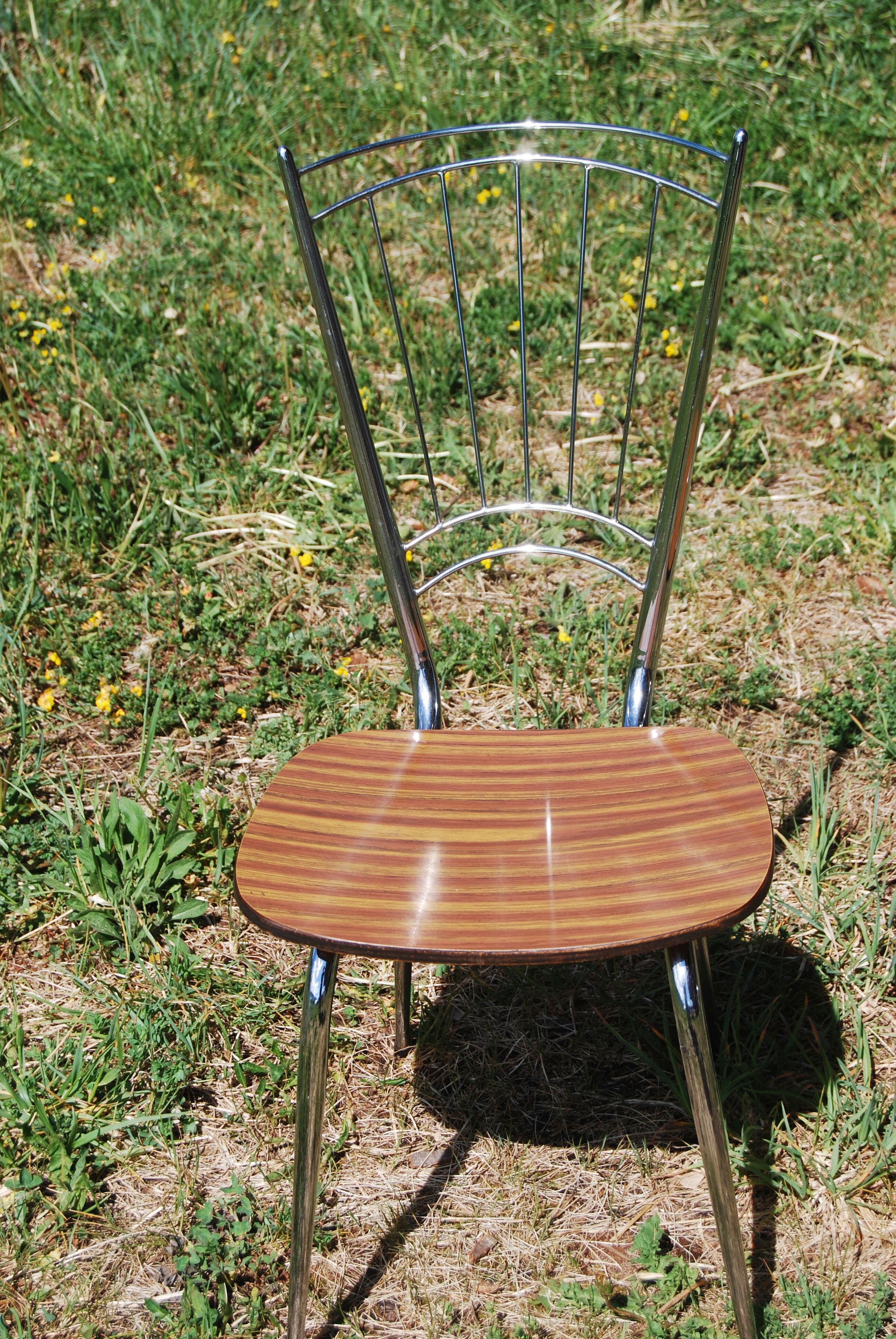 Pair of formica chairs with chrome metal backs in the shape of a lyre.