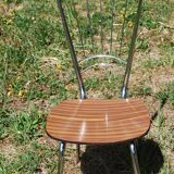 Pair of formica chairs with chrome metal backs in the shape of a lyre.