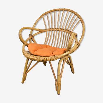 Child wicker chair with orange cushion