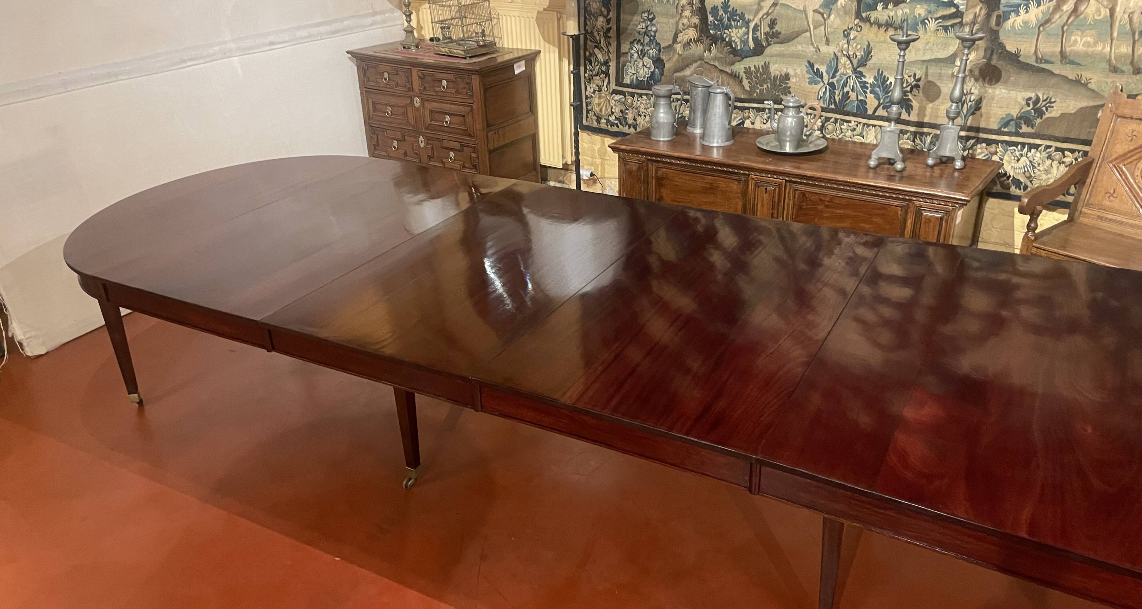 Directoire period extendable dining table in mahogany with a band.