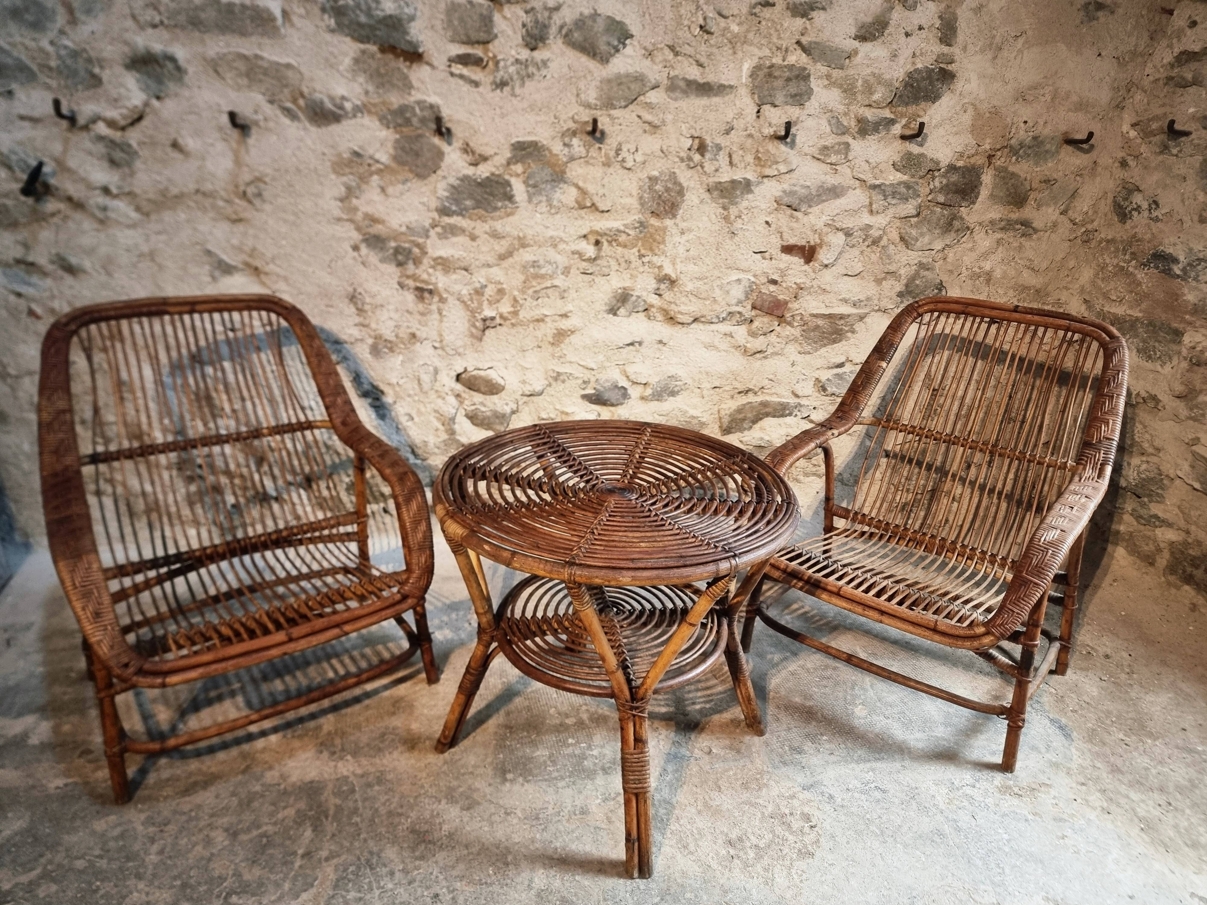 Vintage rattan lounge set, French wicker armchairs and round table, circa 1930–1950.