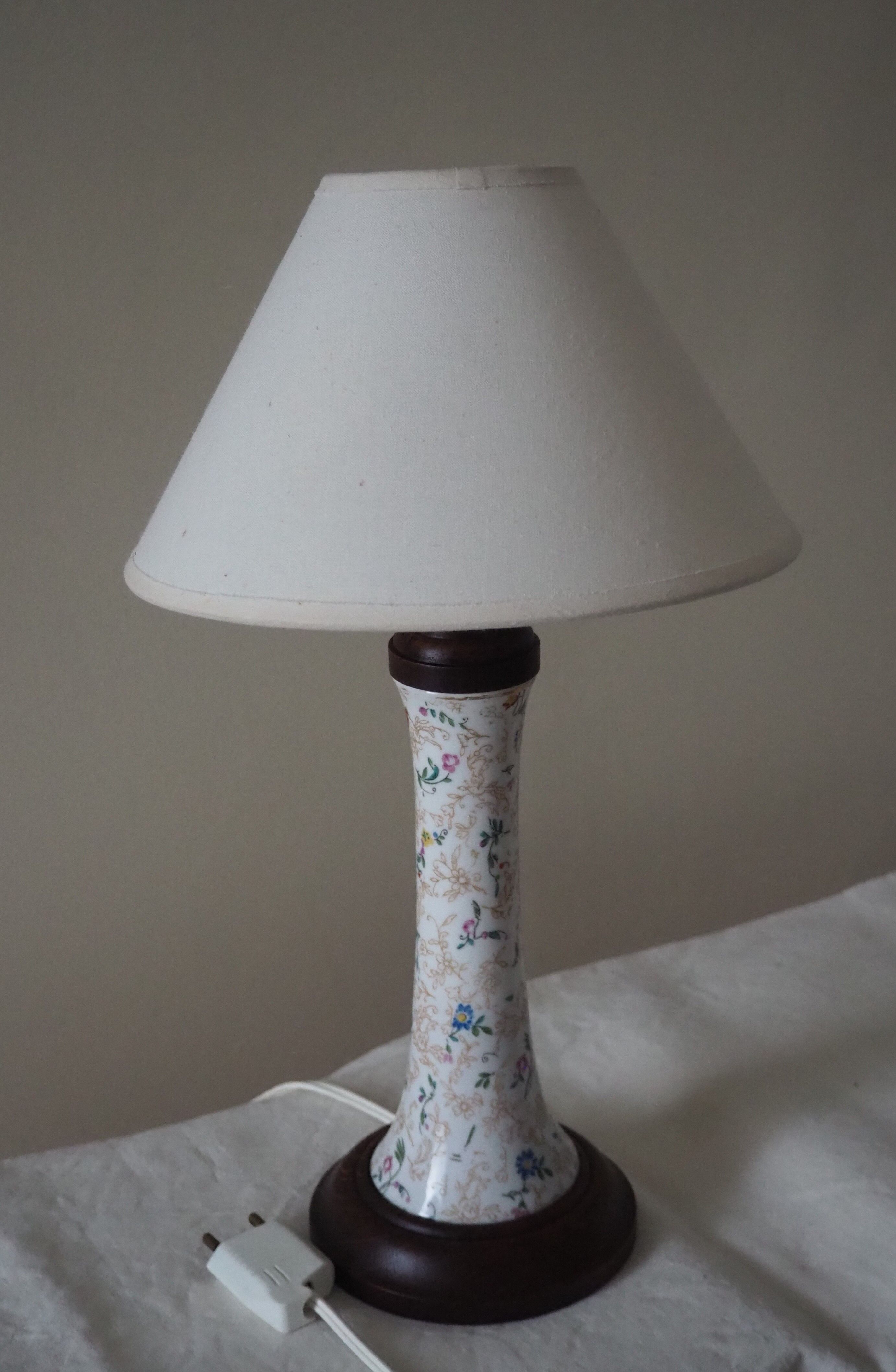 Table lamp for bedside use in earthenware with a wooden base.