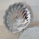 Scallop shell butter dish in stainless steel with its white glass saucer.