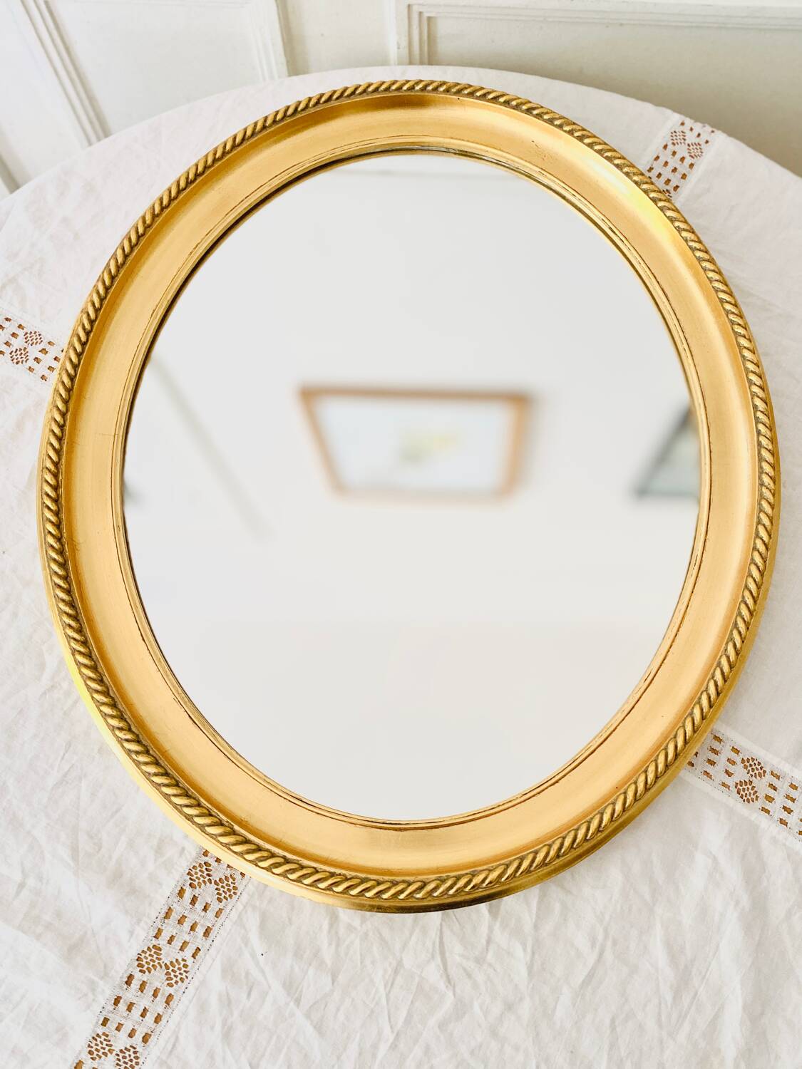 Oval wall mirror in gilded wood
