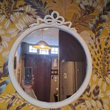 Round mirror in carved wood with at the top a ribbon forming a knot in cream color
