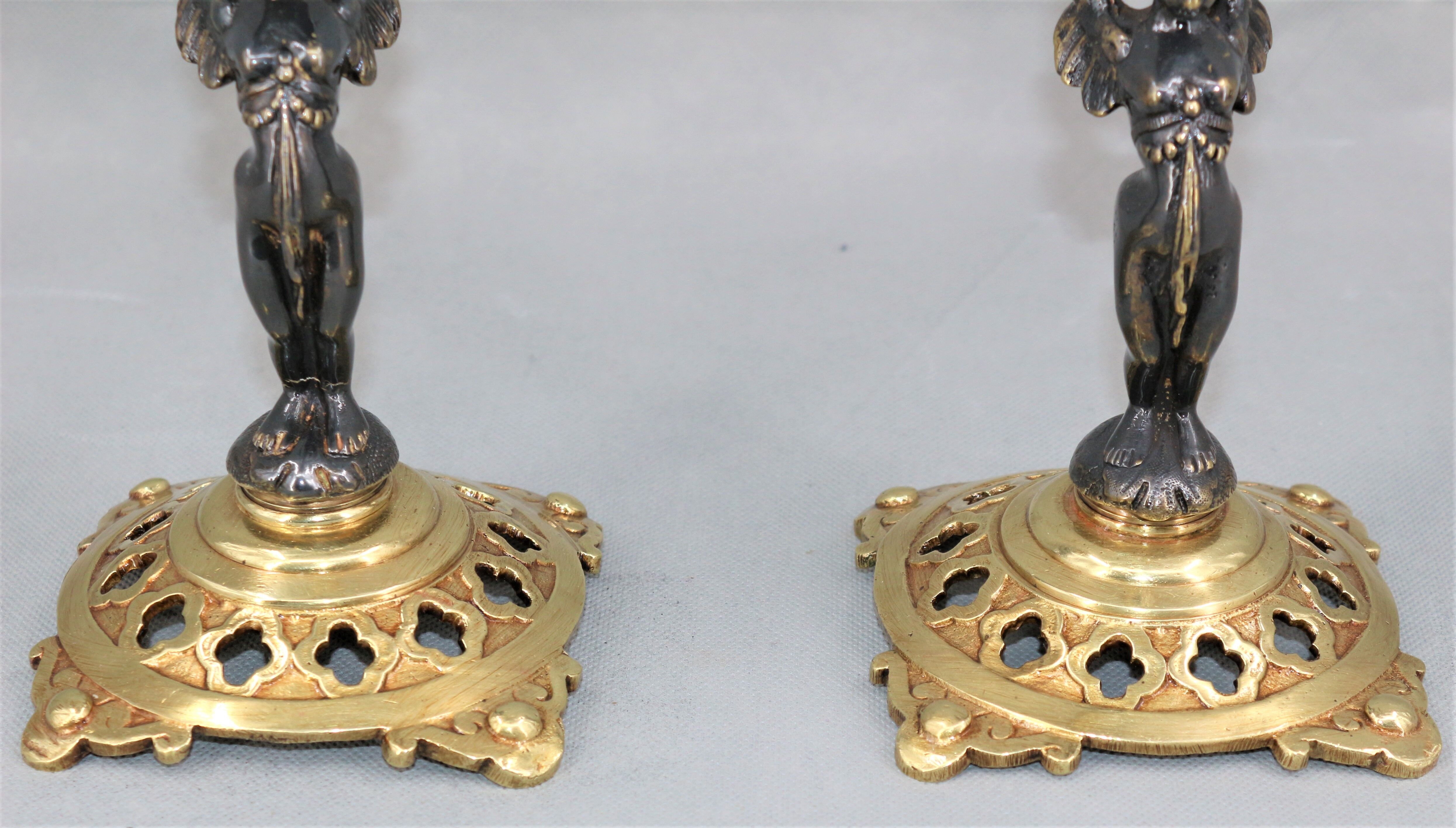 Pair of candle holders in gilded bronze and patinated with a candle
