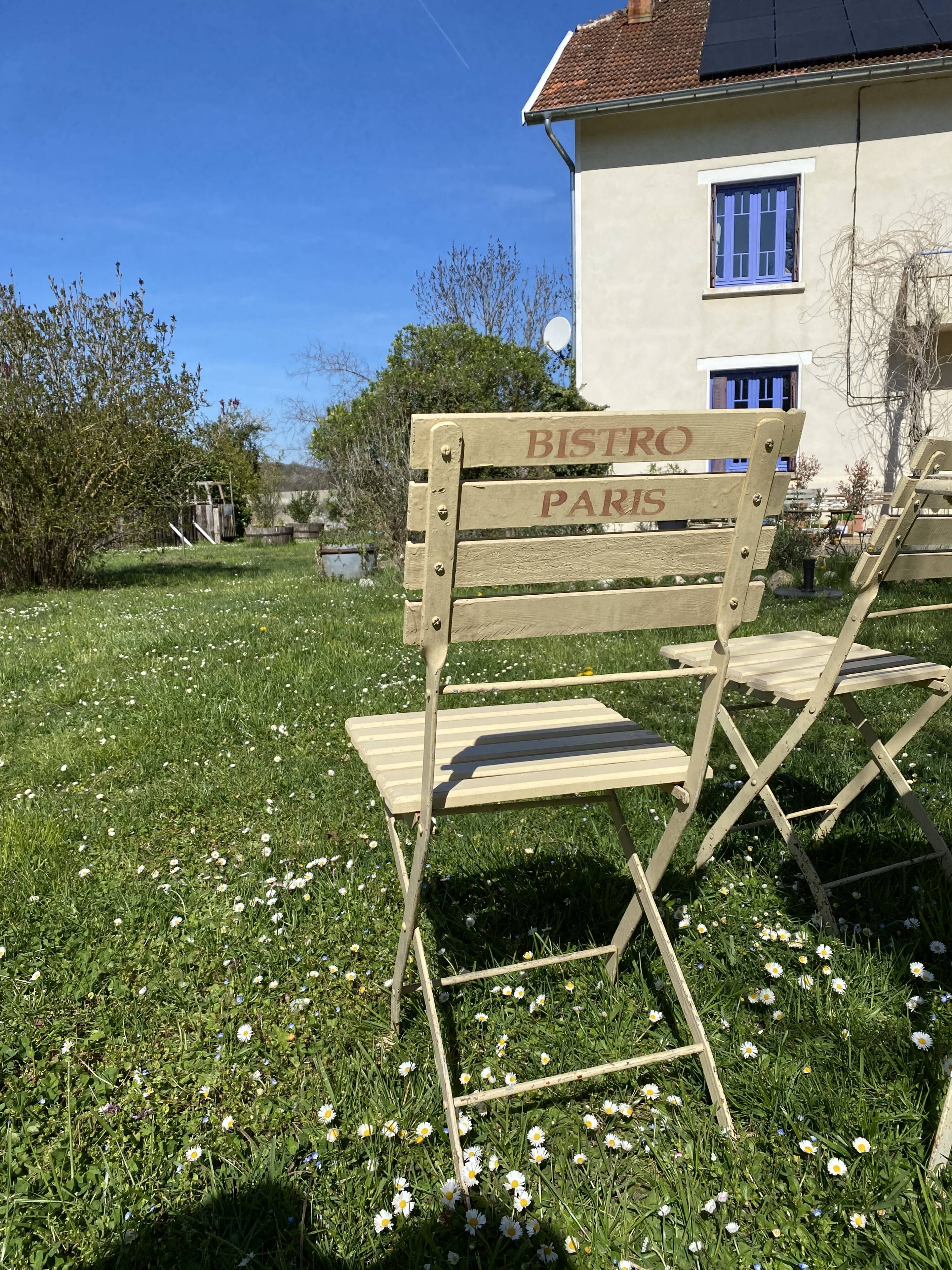 Table et 2 chaises de jardin en métal et bois beige marquées "Bistrot Paris"
