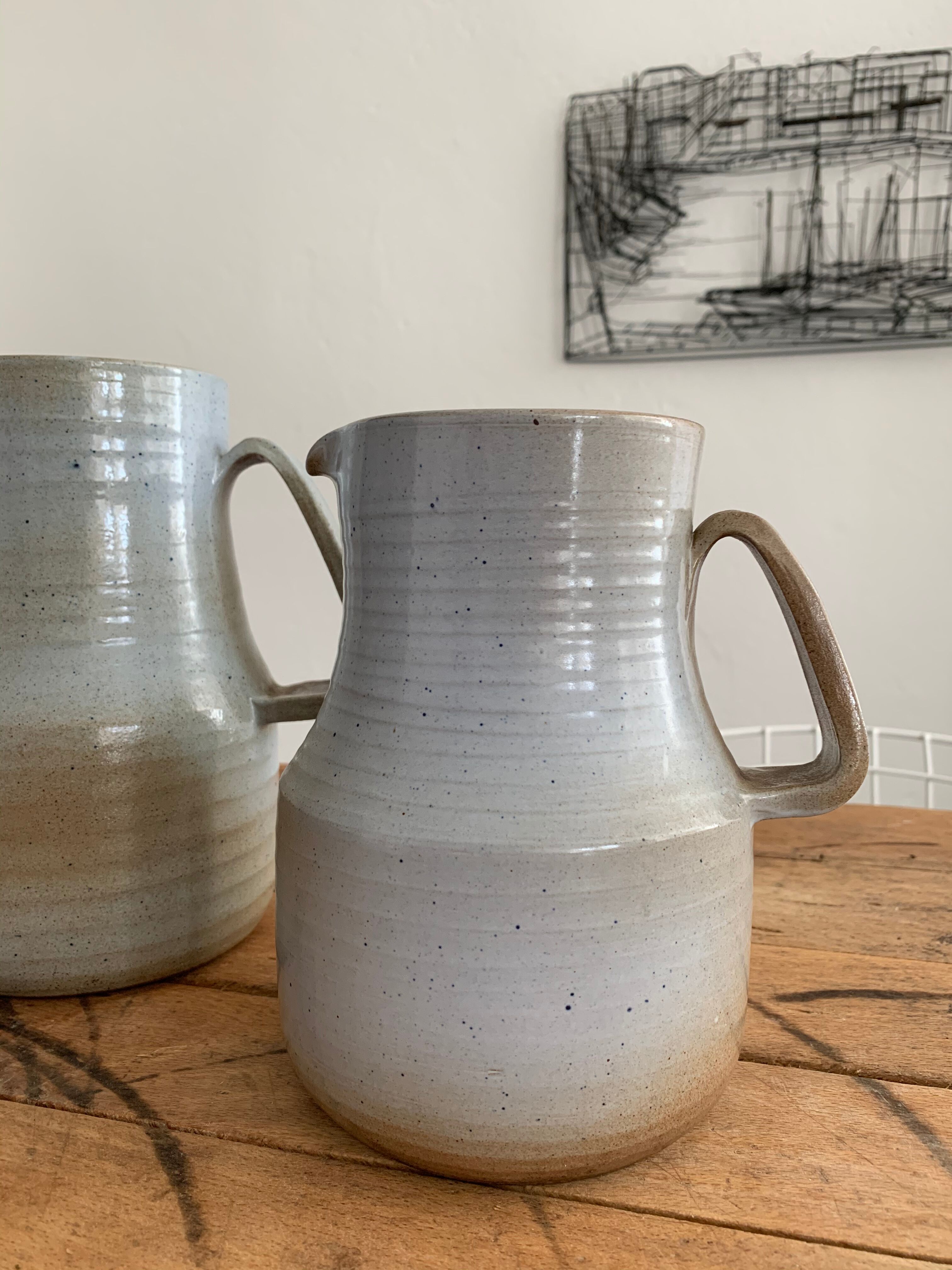 Pair vintage enamelled ceramic pitchers