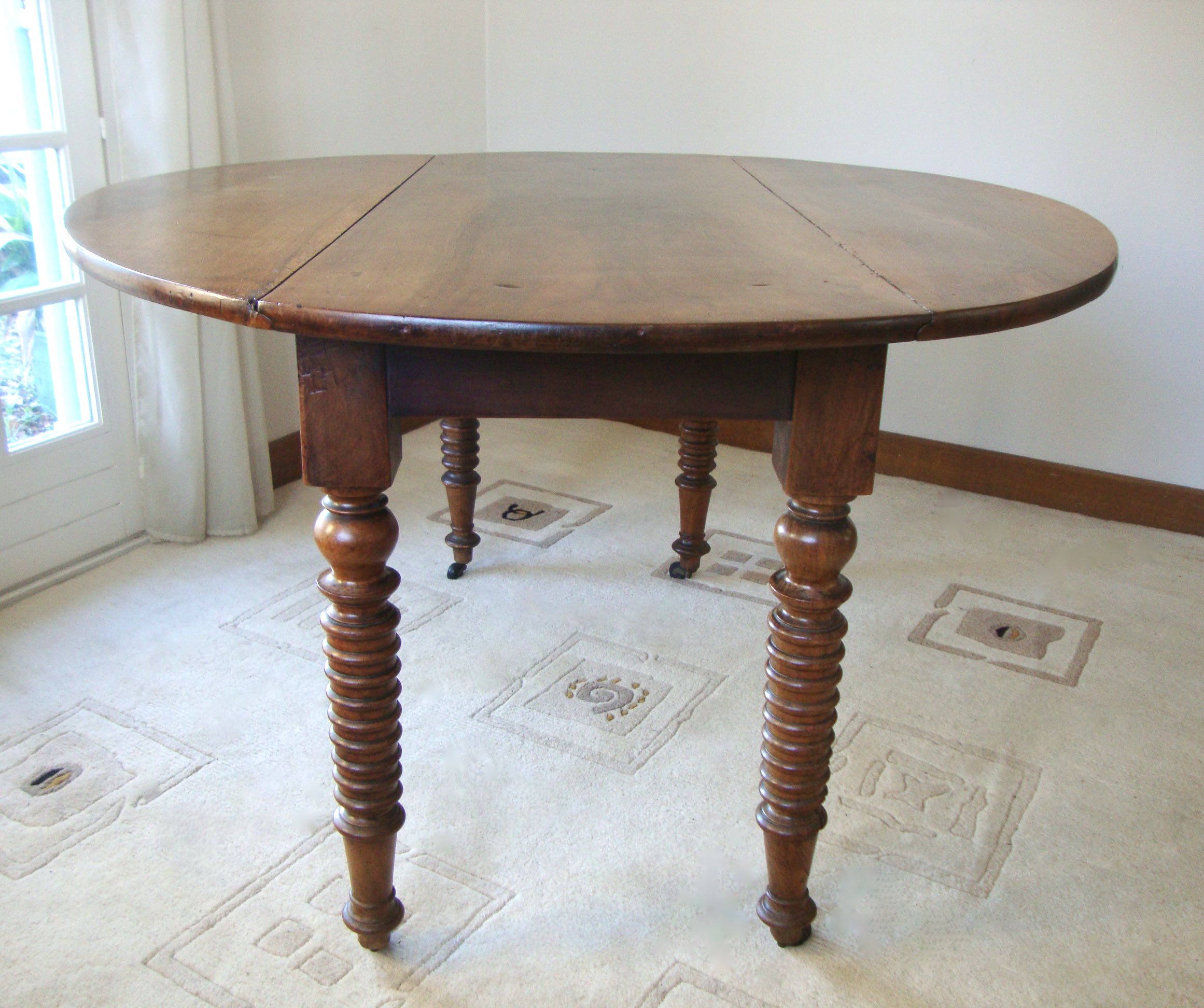 Mid-19th-century walnut round table with shutters, flaps