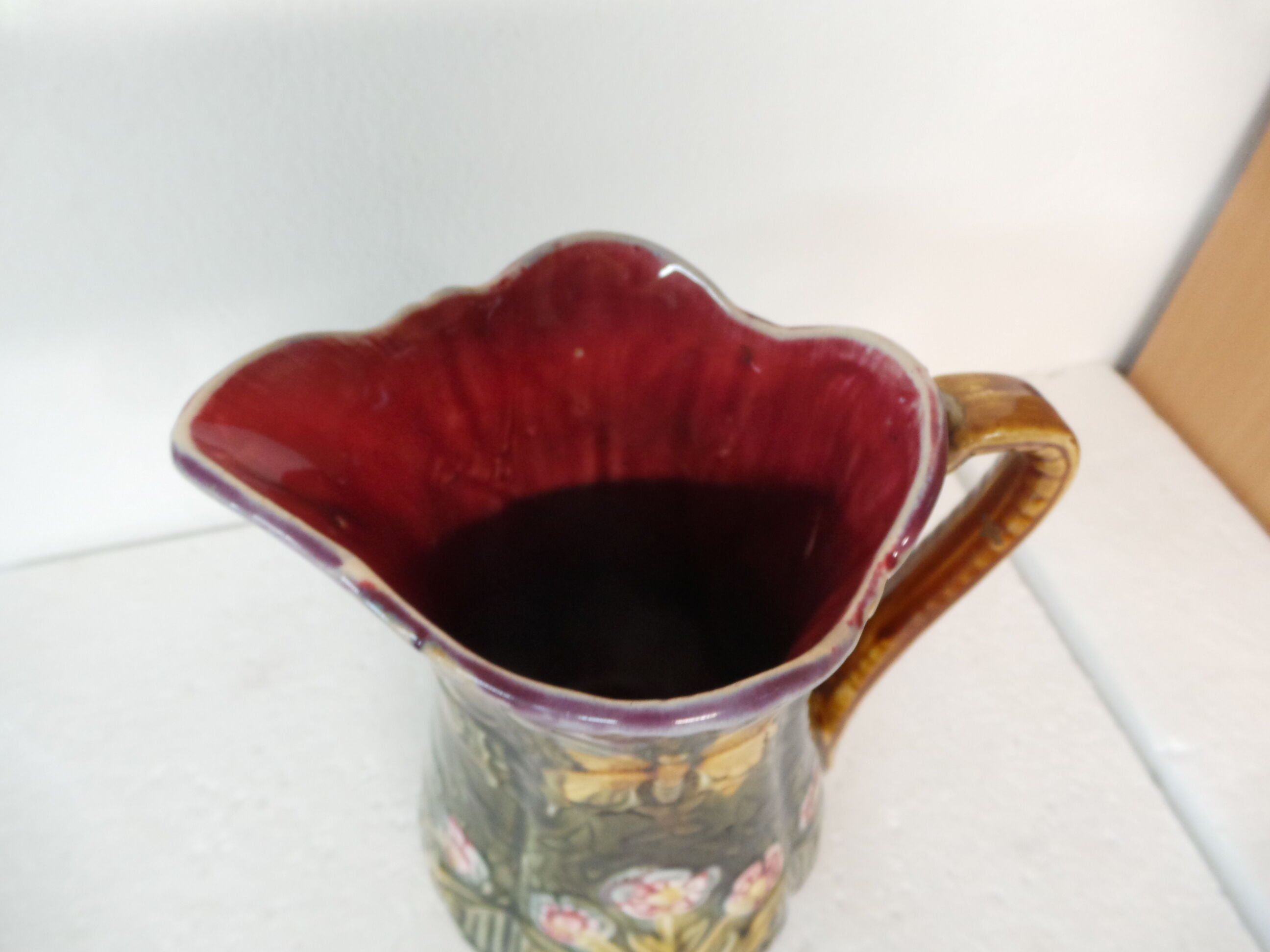 Pitcher dabbling in butterfly and flower decoration