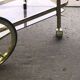 Two-tier bar cart in gold-plated brass with transparent glass shelves, yellow finish.