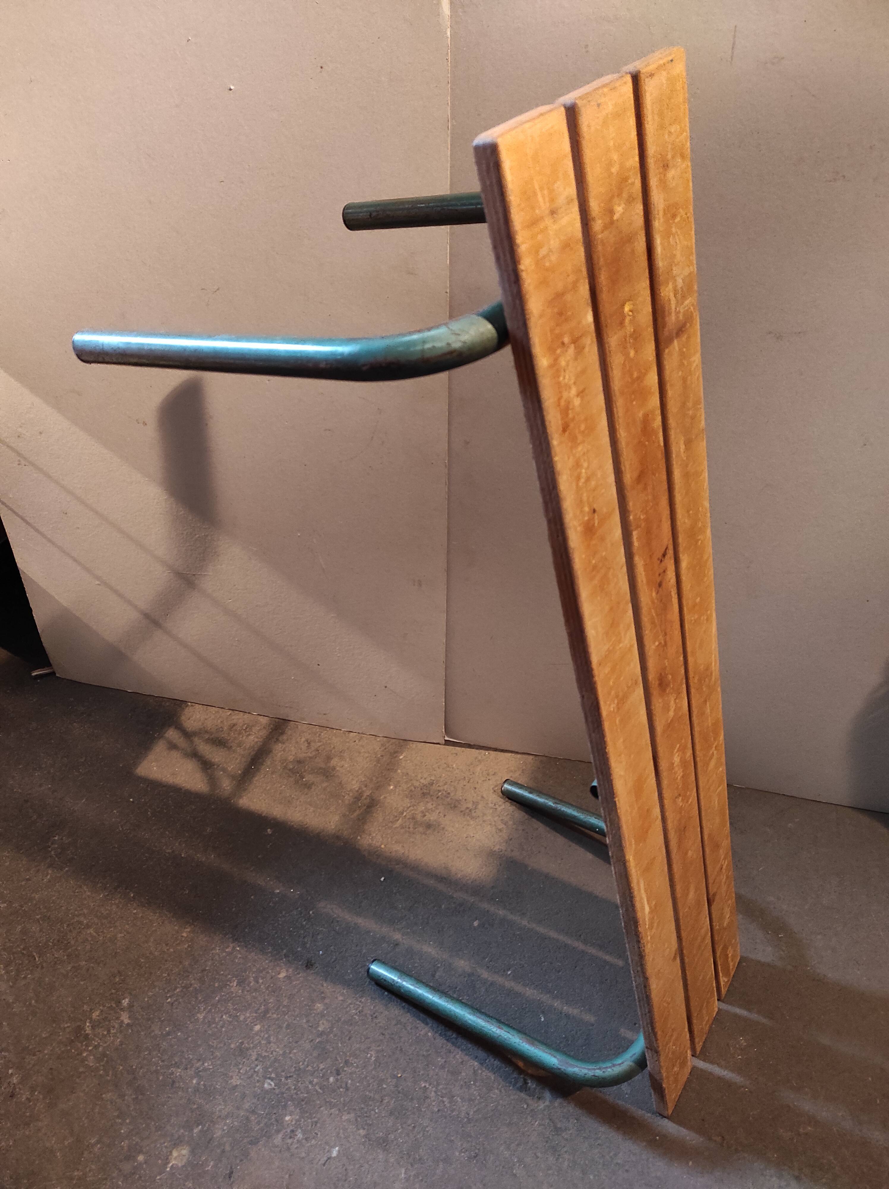 Former vintage wooden school bench and metal tubes