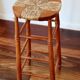 Antique wooden bar stool with a straw seat