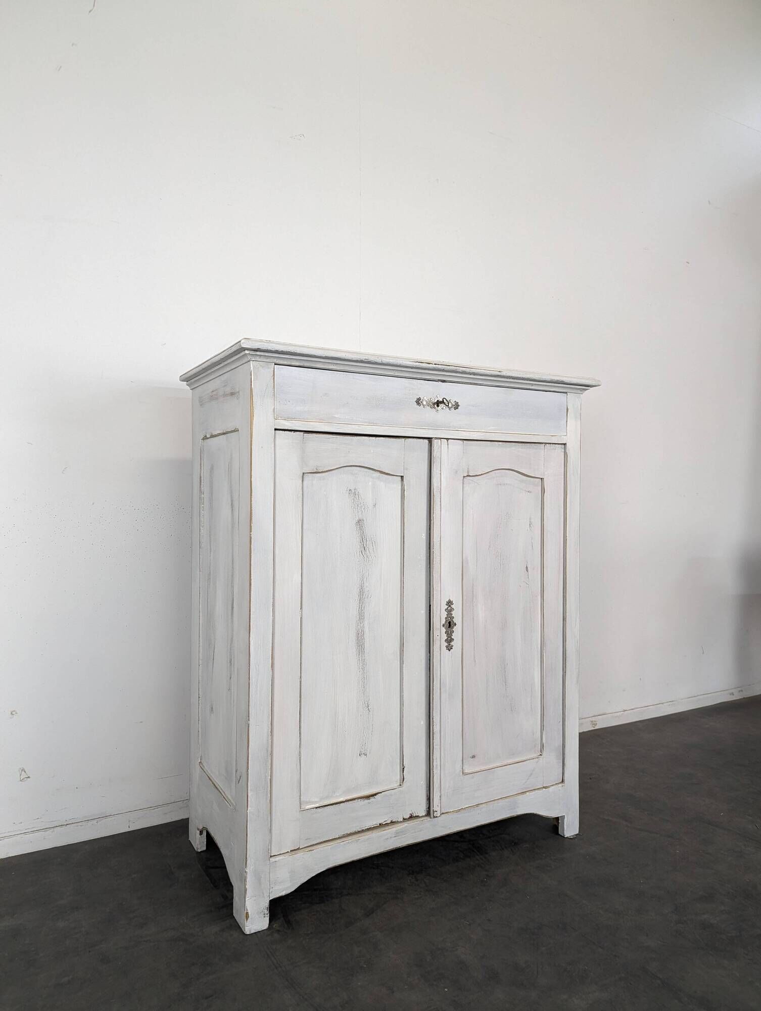 Small buffet with two doors and one drawer in white patinated wood.