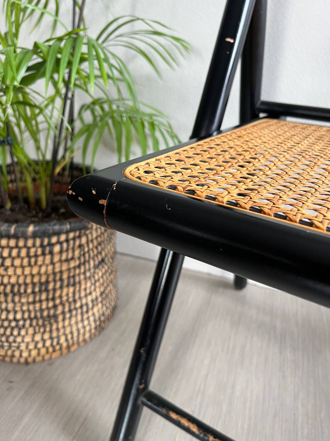 Vintage folding chairs in black wood and cane.