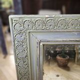 Old mirror with light green contours with mauve shades