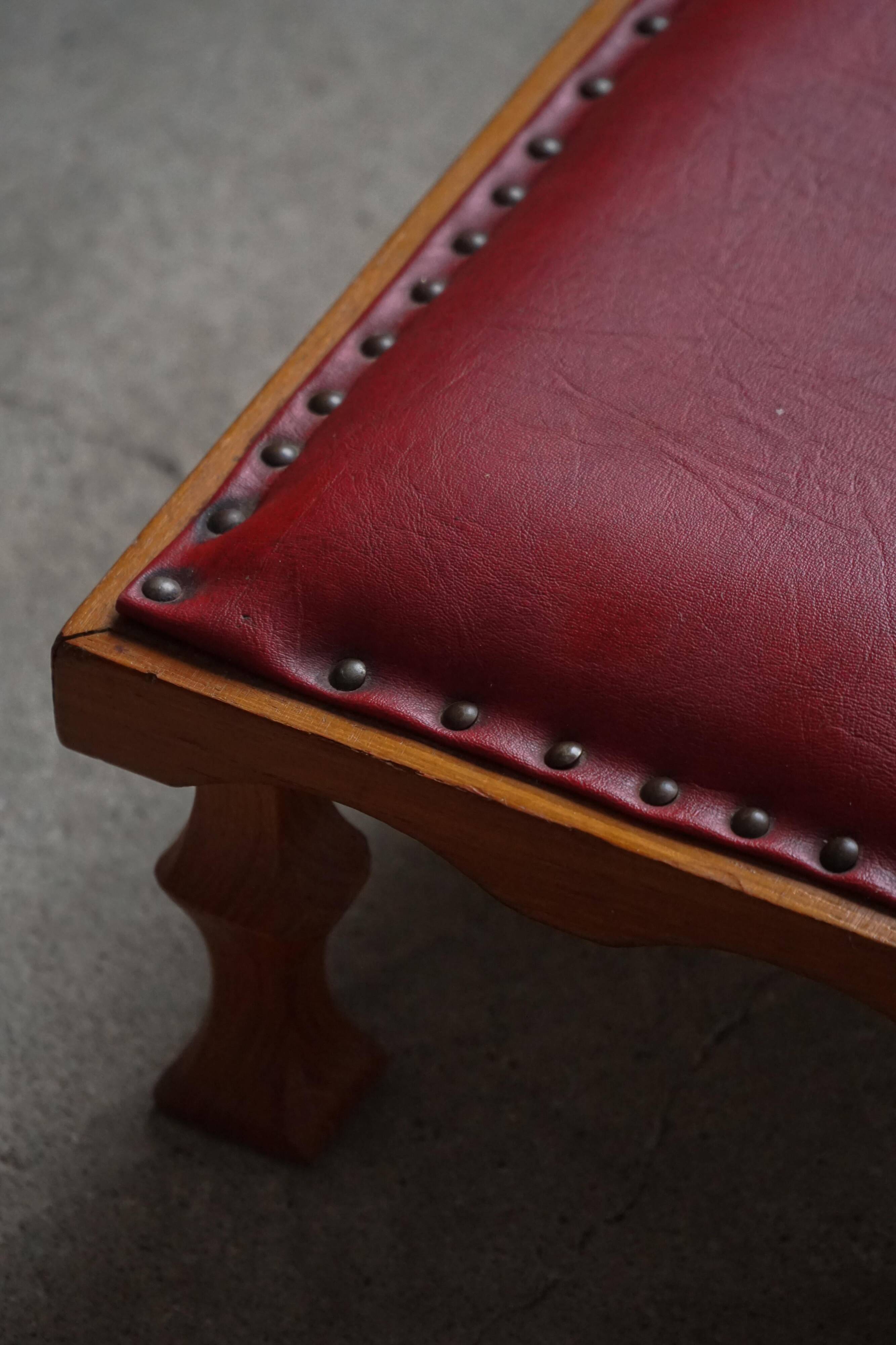 Danish sculpted oak stool from the mid-20th century with a red leather seat, 1950s.