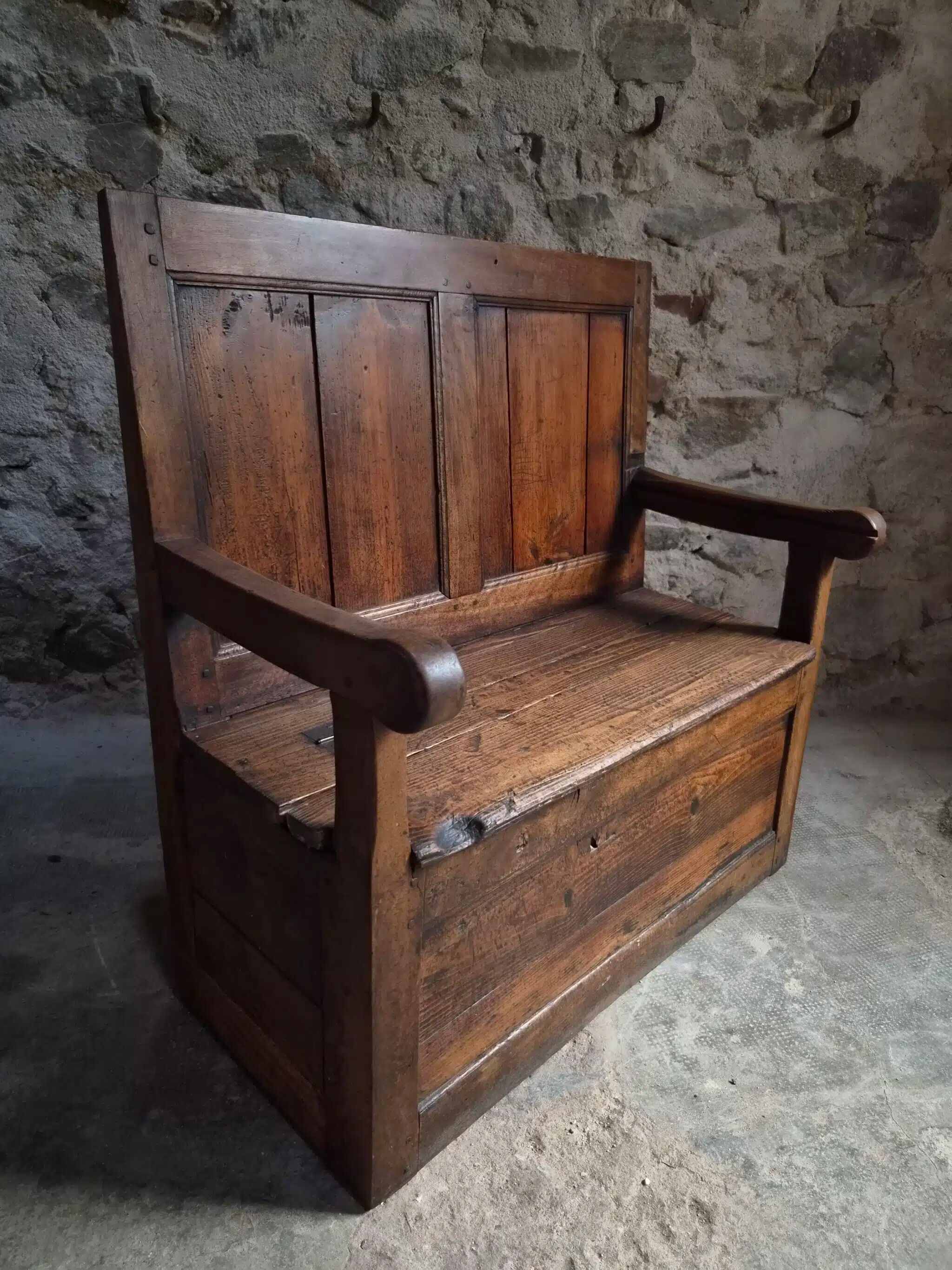 Rustic French antique storage bench from the 18th century in walnut and pine.