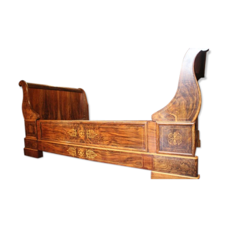Charles X bed in solid walnut with a marked decoration