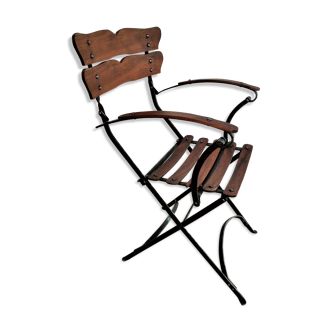 Fauteuil de jardin pliant avec ses lattes de teck sur une structure en fer forgé