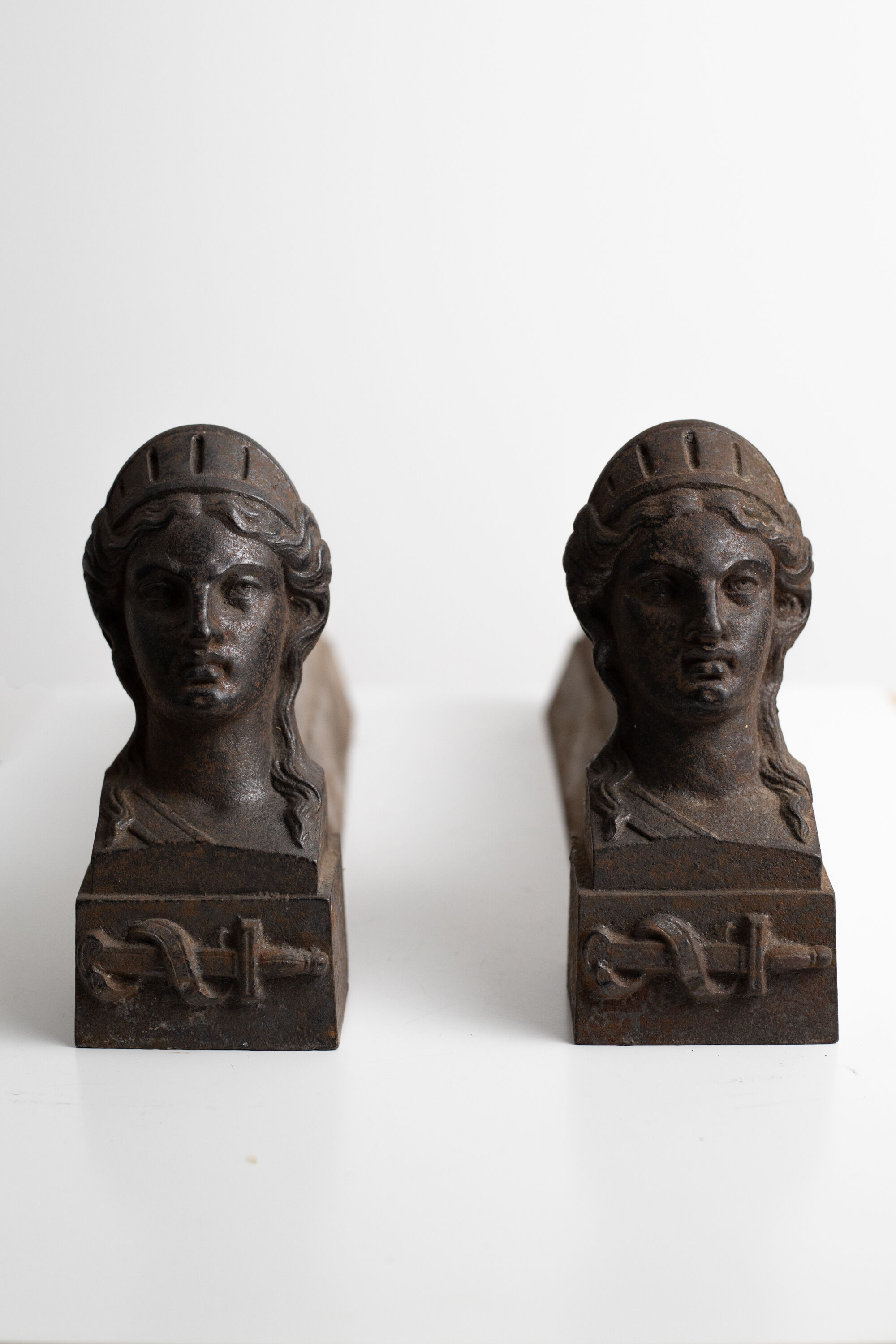 Pair of ancient cast iron chenets adorned with bust of Marianne
