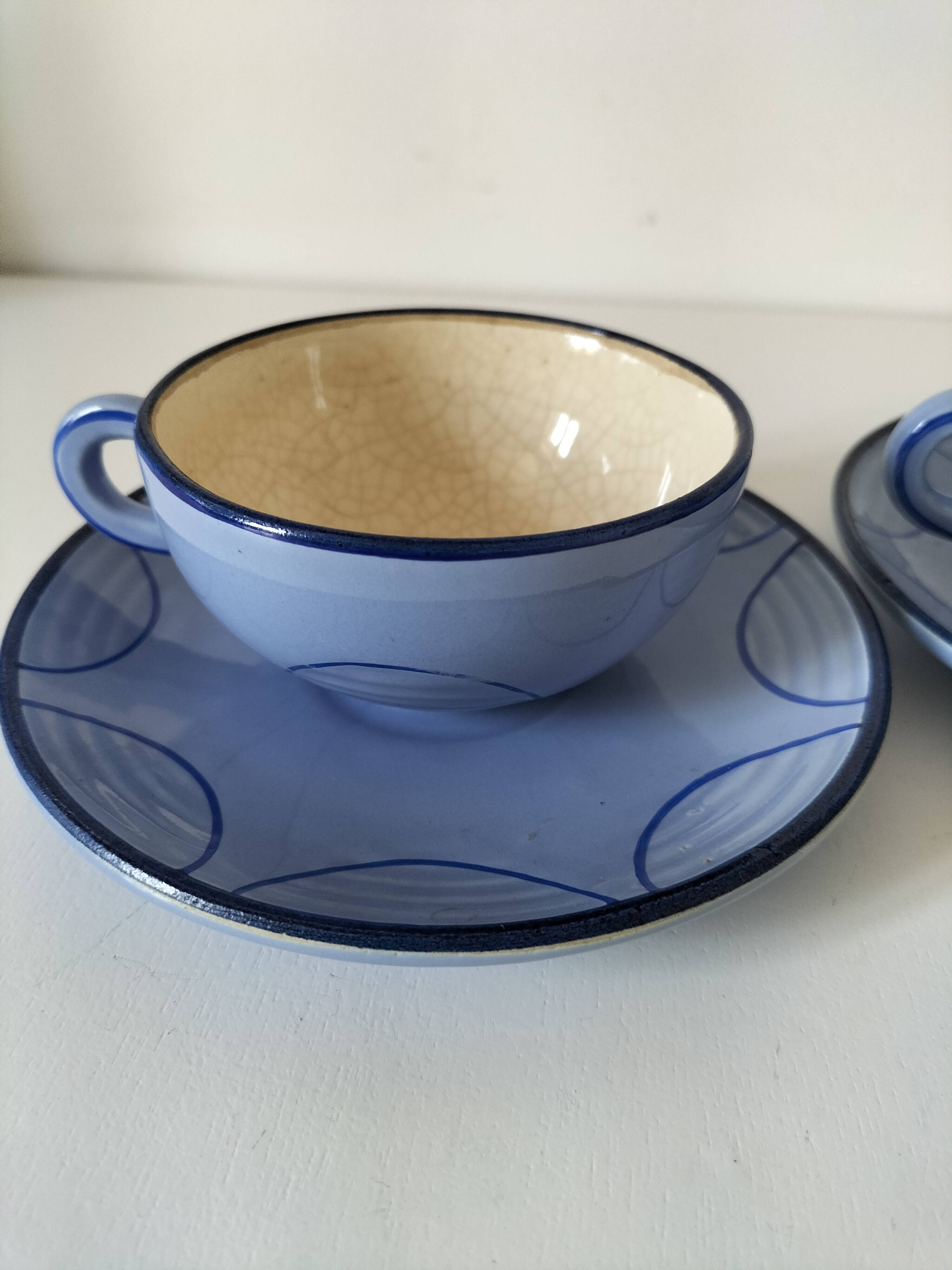 A pair of glazed ceramic cups and saucers from the 60s-70s.