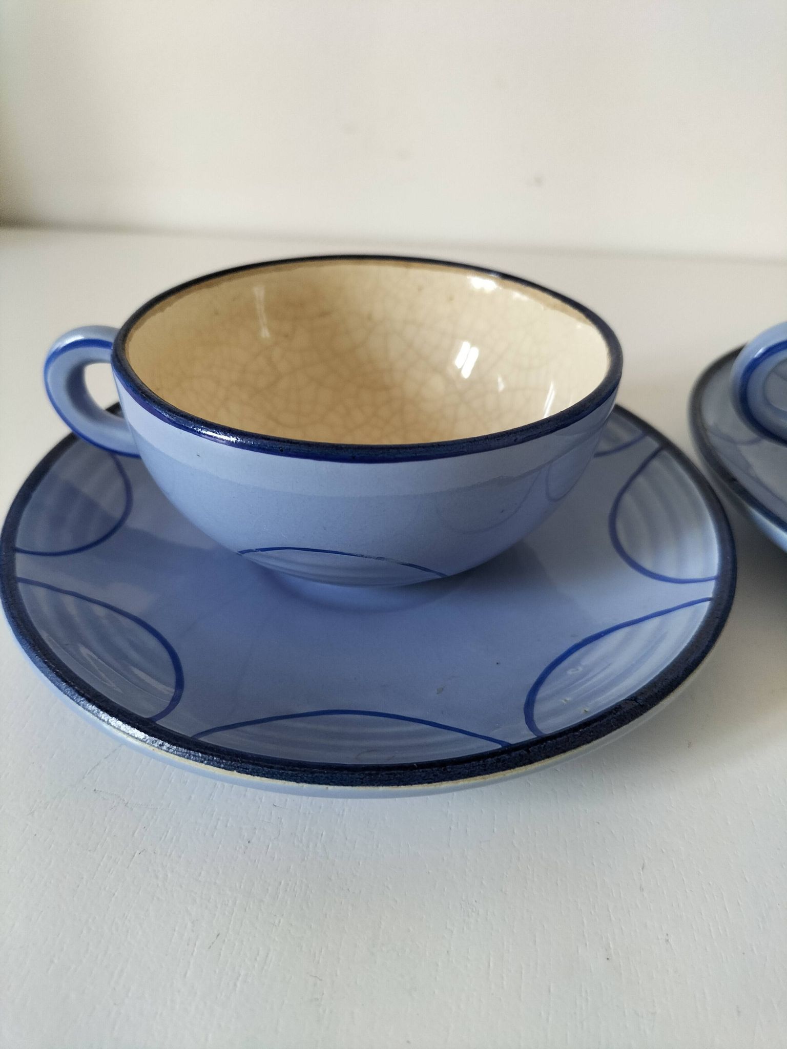 A pair of glazed ceramic cups and saucers from the 60s-70s.