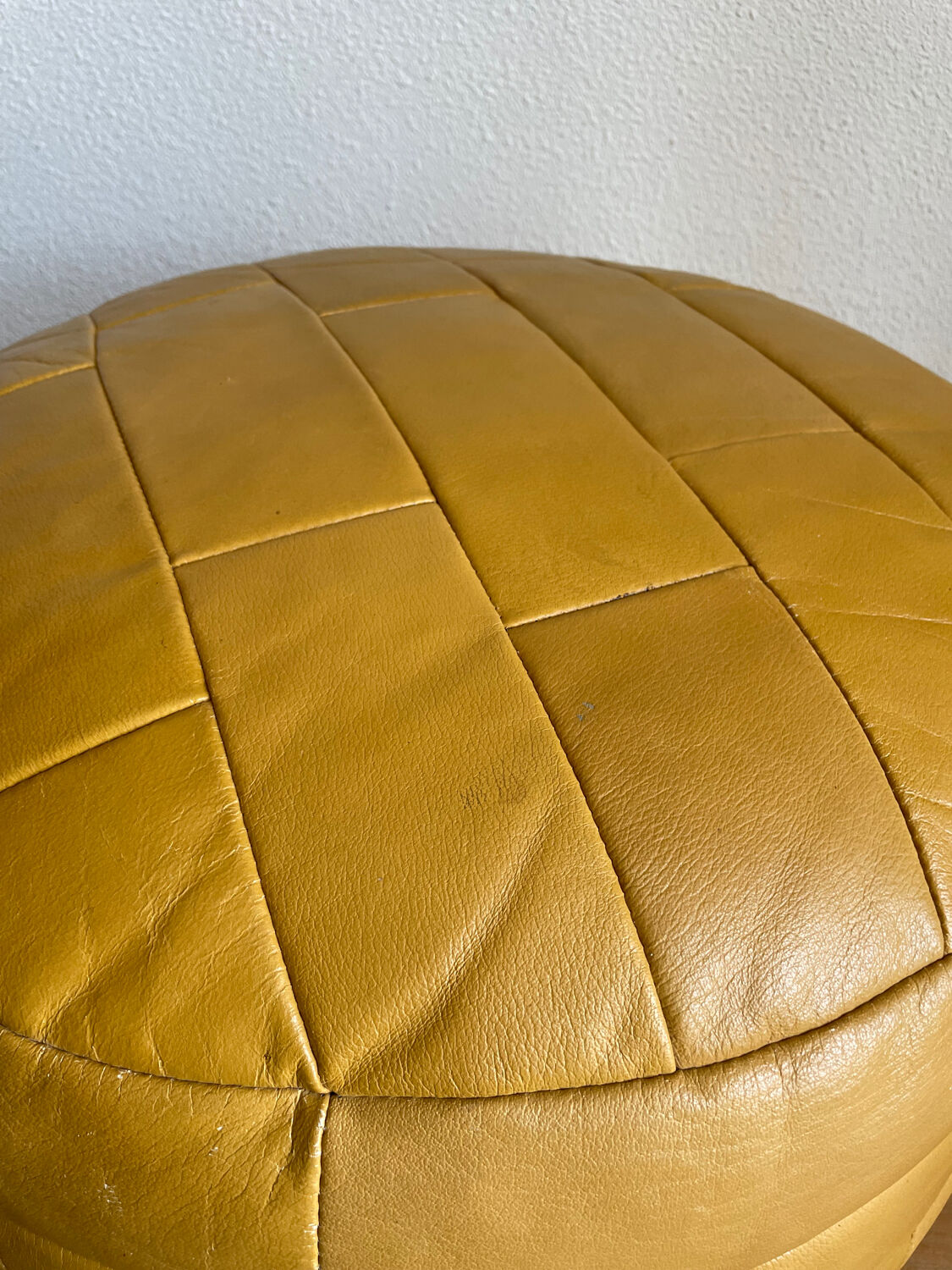 2 poufs moutarde patchwork en cuir de Sède