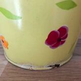 Small metal bucket with floral print on a yellow background