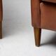 Pair of Art Deco armchairs in brown leather and teak, Netherlands, 1970s.