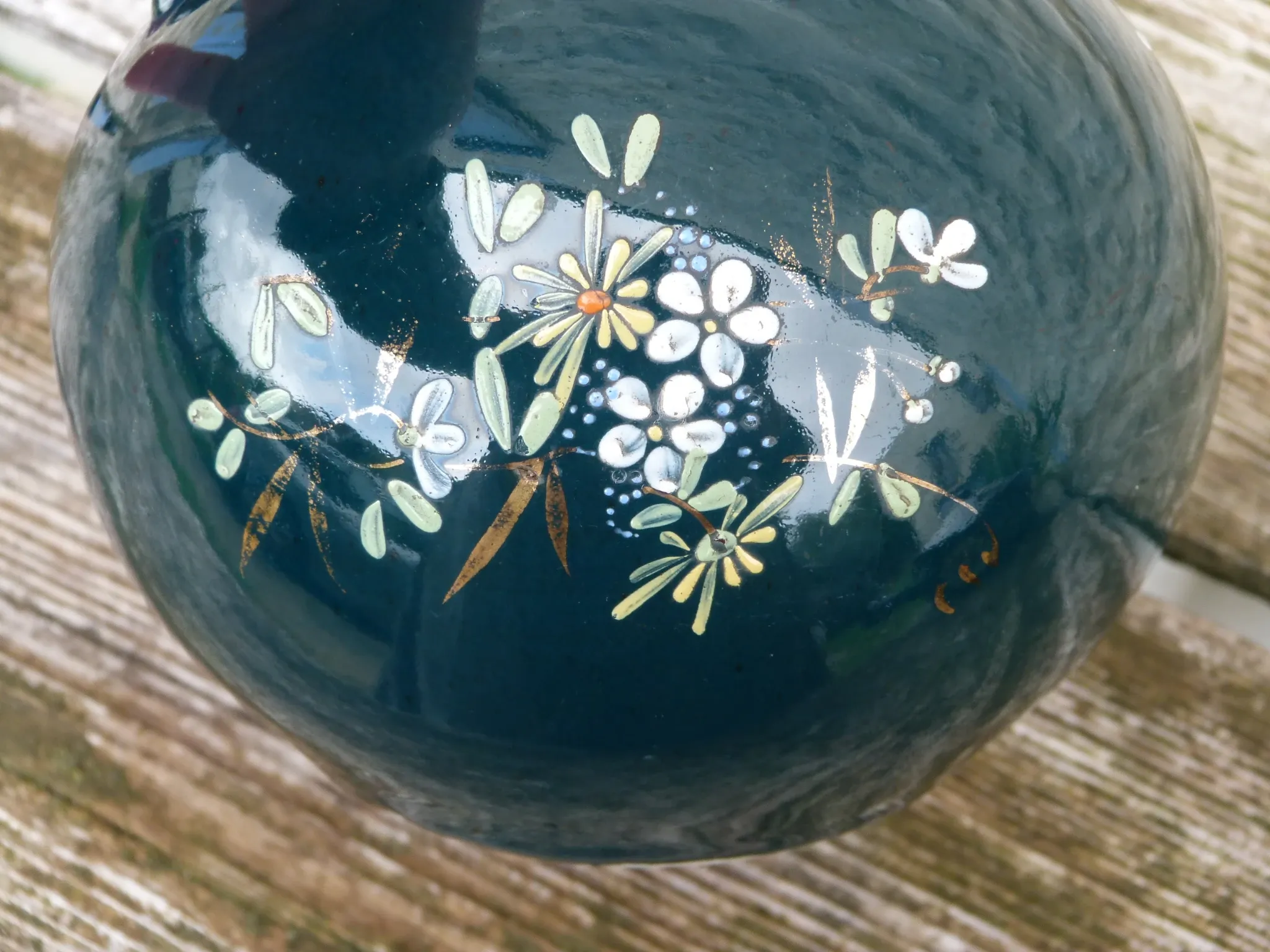 Old ceramic jug with flowers or single-stem vase.