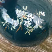 Old ceramic jug with flowers or single-stem vase.