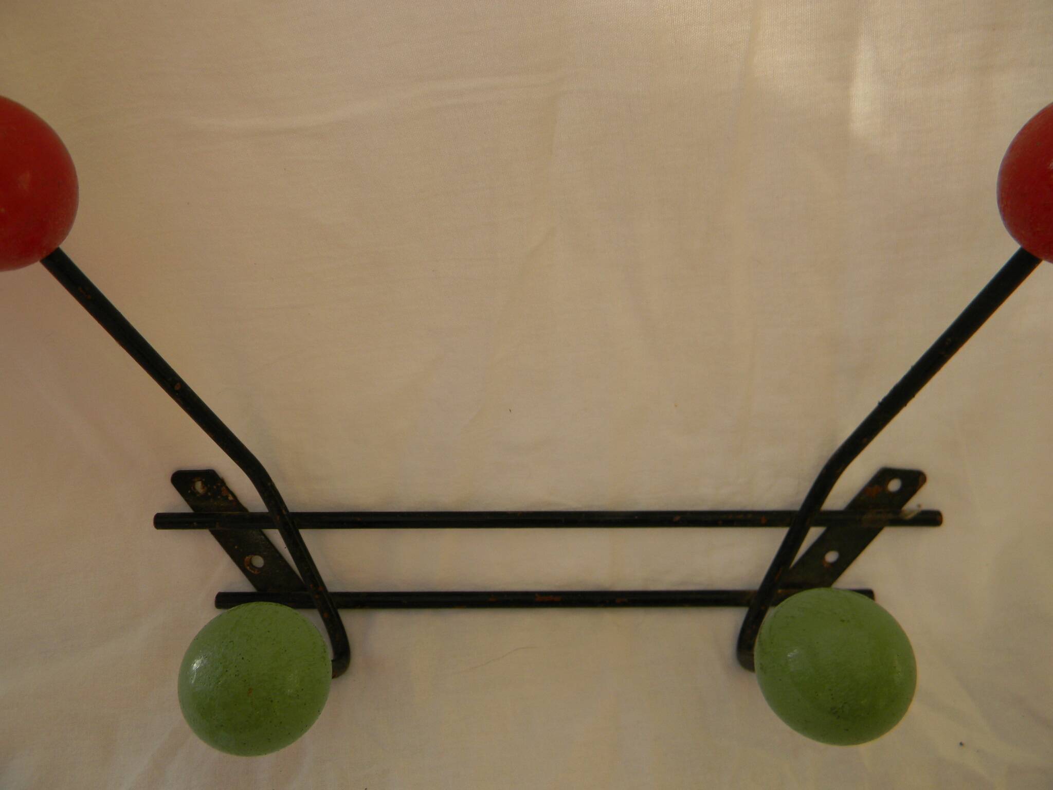 Small wrought iron coat rack with wooden balls.