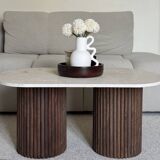 Oval coffee table in travertine and fluted wood.