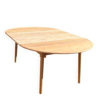 Large round family table with 2 extensions in solid raw wood.