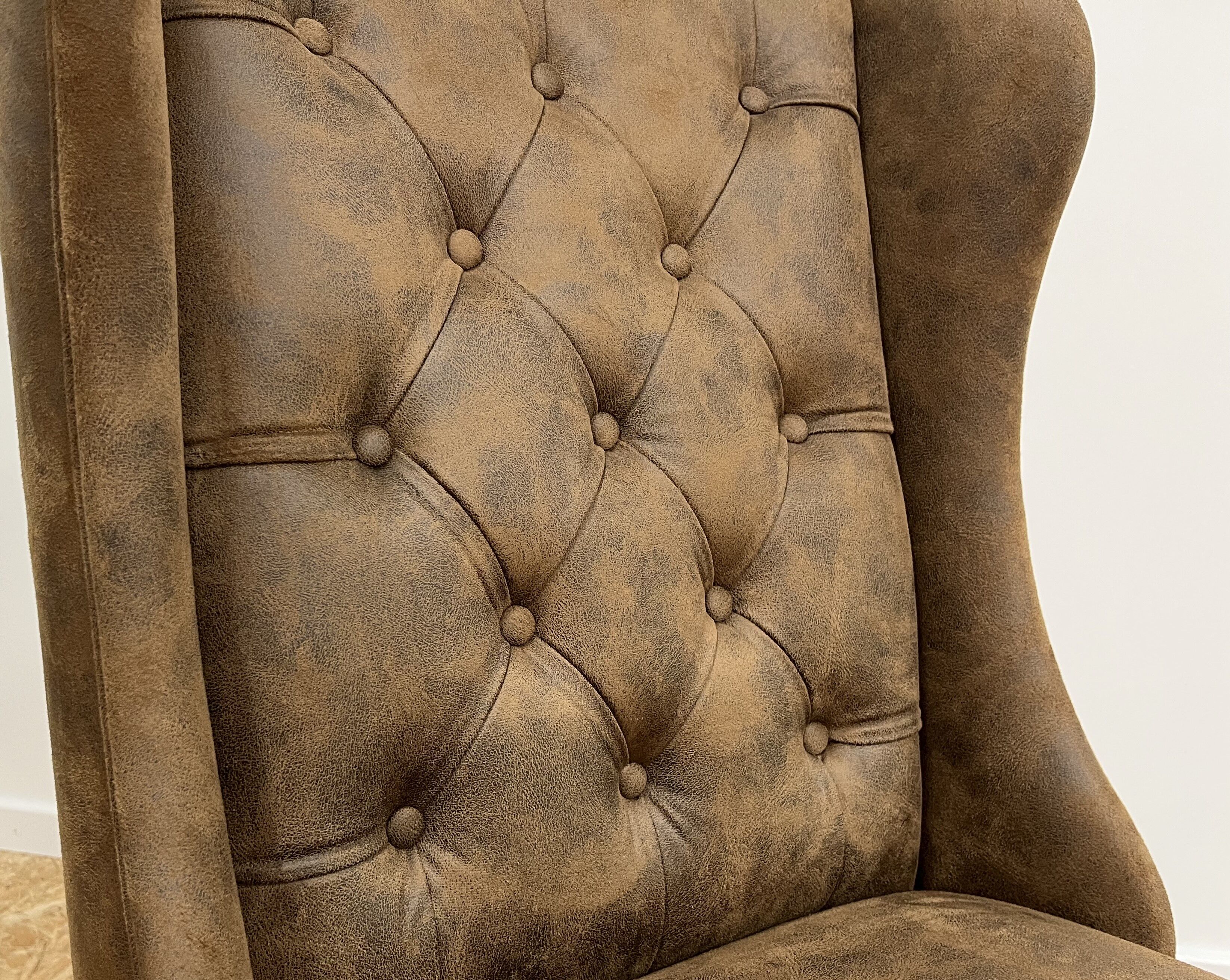 Upholstered armchair in brown imitation leather
